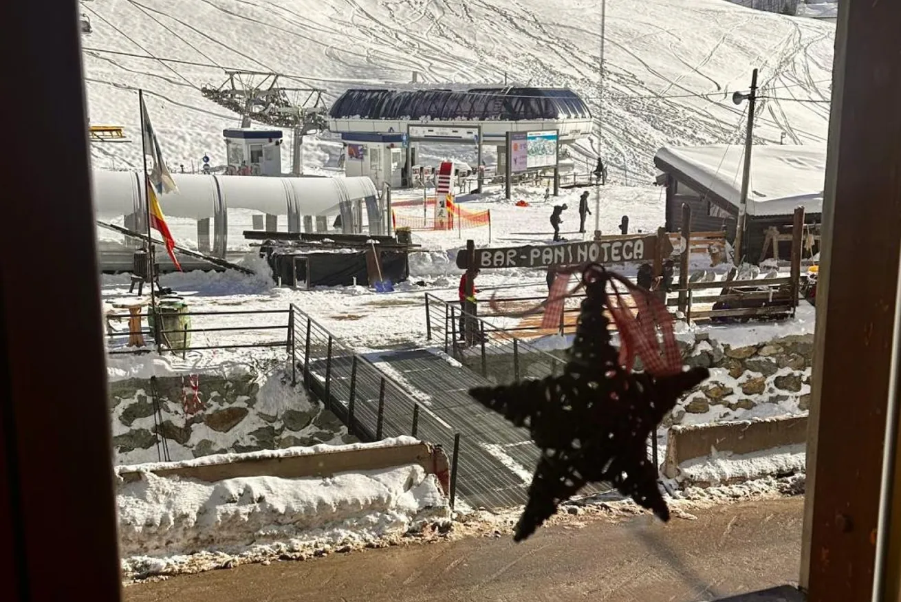 Vista dalla finestra sugli impianti di risalita innevati